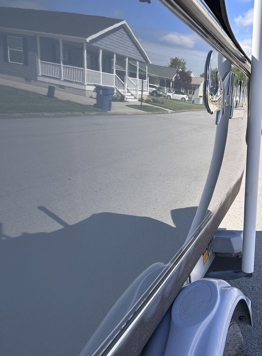 The same gray hull after correction, glossy enough to reflect the houses across the street