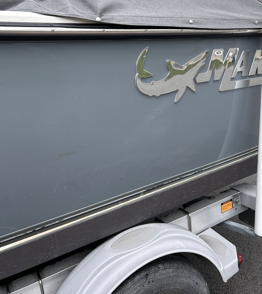 A gray boat hull before correction, dull and hazy with fine scratches